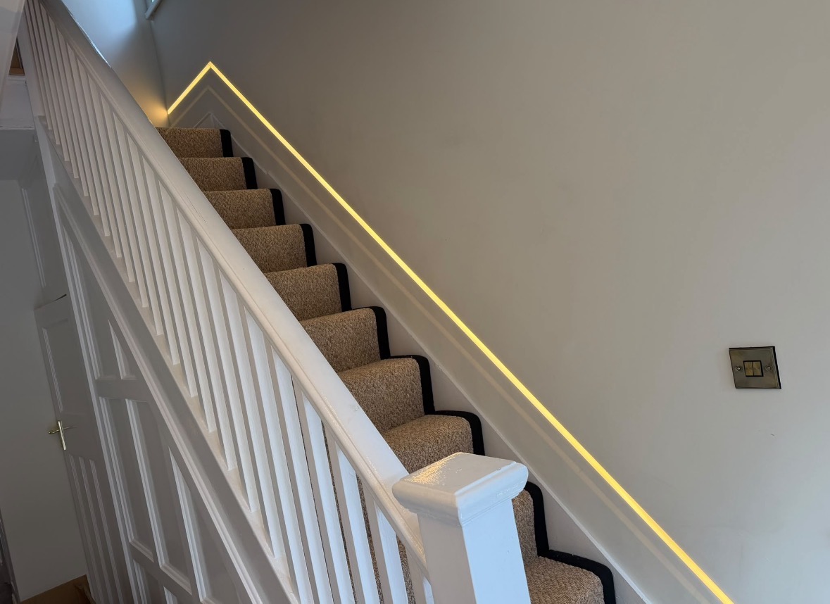 Staircase with a continuous recessed LED feature light following the line of the handrail