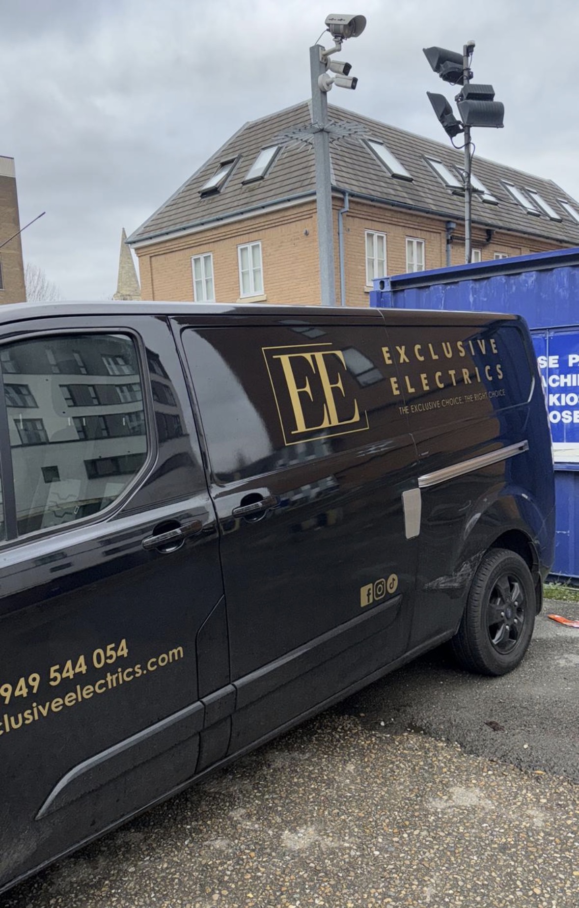 External CCTV cameras and LED floodlights mounted on a column beside an Exclusive Electrics van on site