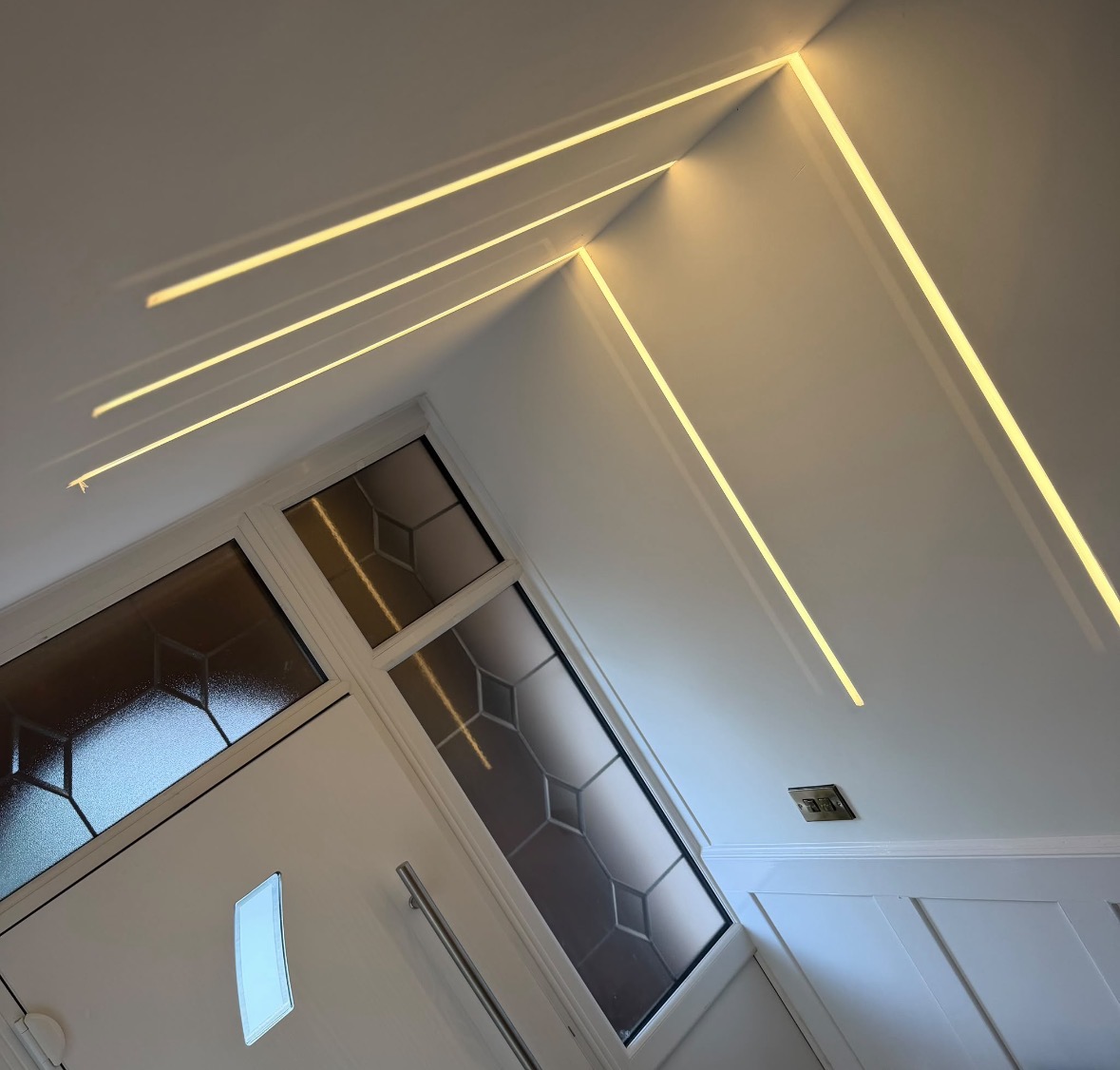 Entrance hall ceiling with plaster-in linear LED lighting forming clean geometric lines above the front door